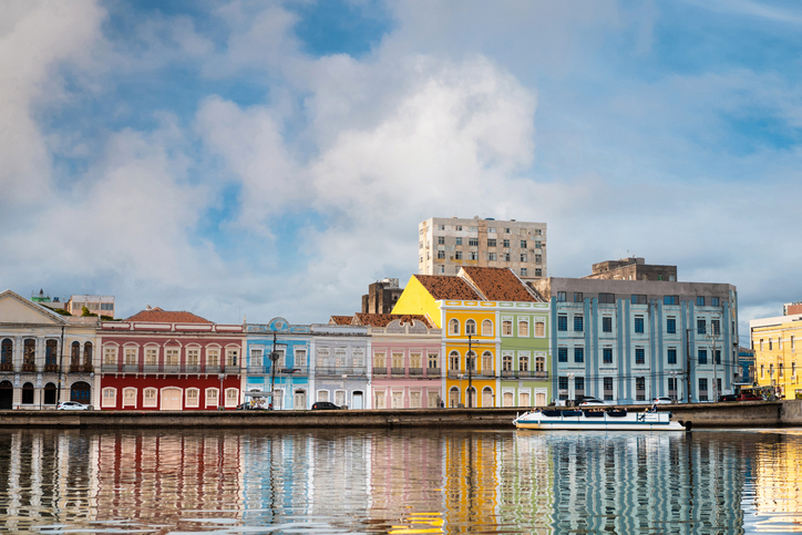 A imagem mostra casas coloridas na margem do Rio Capibaribe em Recife, Pernambuco, Brasil.